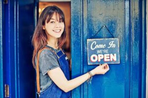 lady holding blue open sign